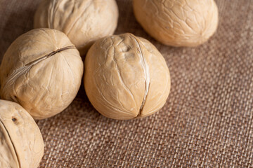 Mixed nuts on a white wooden fabric texture background.