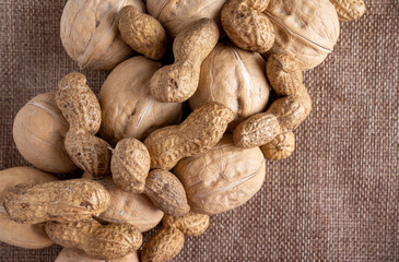 Mixed nuts on a white wooden fabric texture background.