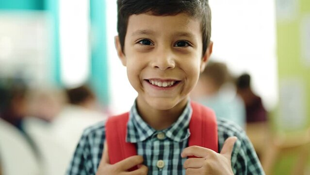 Adorable hispanic boy student smiling confident standing at classroom