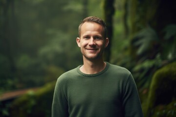 Portrait of a handsome young man smiling in the rainforest.