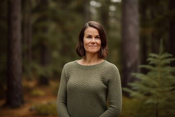 Portrait of a beautiful woman in a green sweater in the forest
