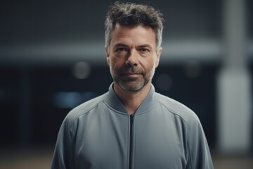 Portrait of confident middle aged man in sportswear standing in gym