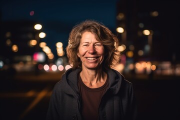 Fototapeta premium Portrait of a beautiful middle-aged woman in the city at night