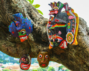 Obraz premium Beautiful Sri Lankan carved wooden traditional masks hanging on a tree