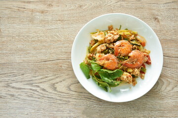 spicy chili stir fried mashed chicken and shrimp with basil leaf on plate