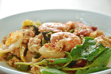 spicy chili stir fried mashed chicken and shrimp with basil leaf on plate