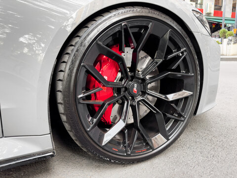 Yerevan, Armenia, April 15, 2023 : Front view of logo of Audi RS7 on alloy wheel. Car exterior details. Tyre and alloy wheel with water drops. Carbon Ceramic brakes.