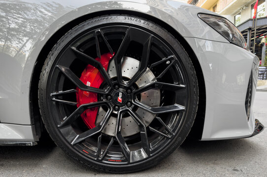 Yerevan, Armenia, April 15, 2023 : Front view of logo of Audi RS7 on alloy wheel. Car exterior details. Tyre and alloy wheel with water drops. Carbon Ceramic brakes.