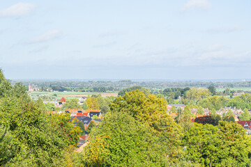 the typical small Dutch village called Beek behind the trees of the forest de Devilsmountain in Gelderland, the Netherlands, Europe