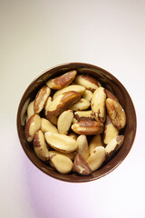 Brazil nuts in a dark ceramic bowl. Top view.