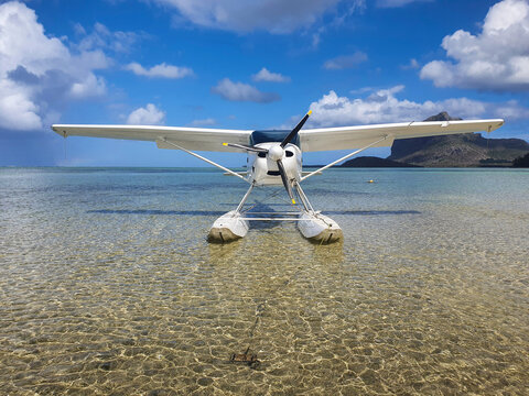 Pequeno avião de hélices pousado sobre a água da praia pronto para a diversão