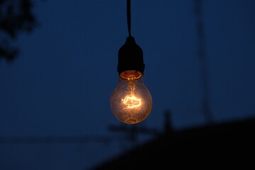 photo of yellow light bulb glowing at night