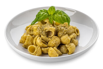 Macaroni pasta with pesto in a white dish with basil leaves, pesto is a typical Genoese sauce of basil, pine nuts, olive oil and parmesan cheese. Isolated .