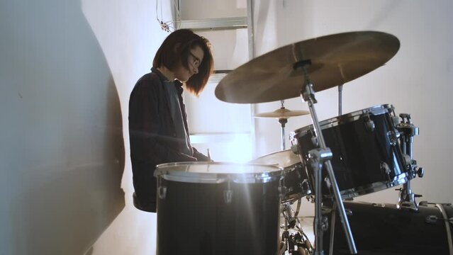 portrait guy drummer sitting at the drum kit in the light of a lamp
