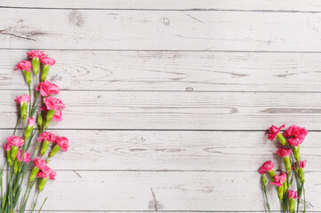 Red and pink carnations bouquet on wooden background. Mother's Day background. Love mom. Copy space.