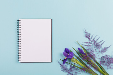 Mother's or Women's Day mock up card from spring irises flowers. Blank diary, notepad mockup with...