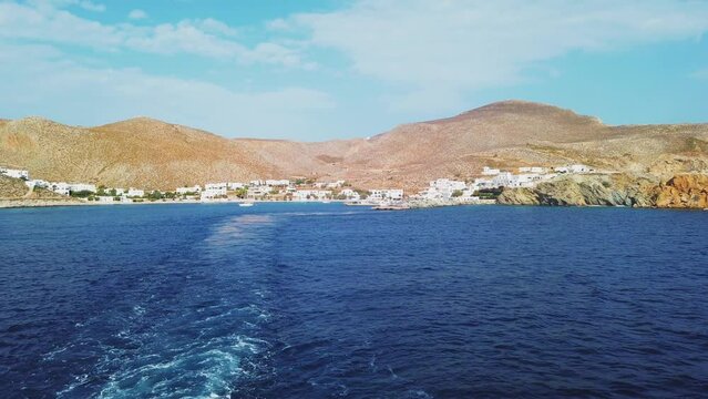 Folegandros, Greece- 26 September 2020: View of the harbor of Folegandros Island. People on the quay, moored yachts. White buildings in the background.