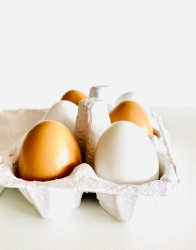 Close-up of brown and white eggs in an egg carton on a table