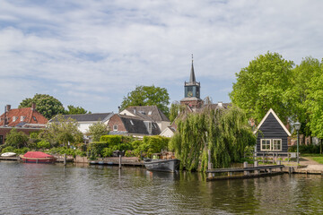 Fototapeta na wymiar Picturesque village of Nigtevecht on the river Vecht with a view of the 13th century church tower of the reformed church.