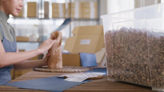 Eco vendor go green packaging parcel carton box in net zero waste store asian seller retail shop. Earth care day small SME owner asia people wrap reuse brown paper pack gift reduce plastic free order.