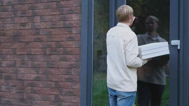 man delivering pizza to the door of the house