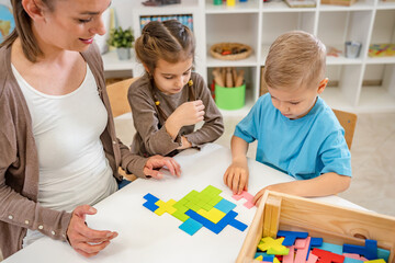 Teacher with children in a Kindergarten Classroom. Healthy learning environment. Kindergarten teacher, building relationships with the kids. Cheerful preschool children