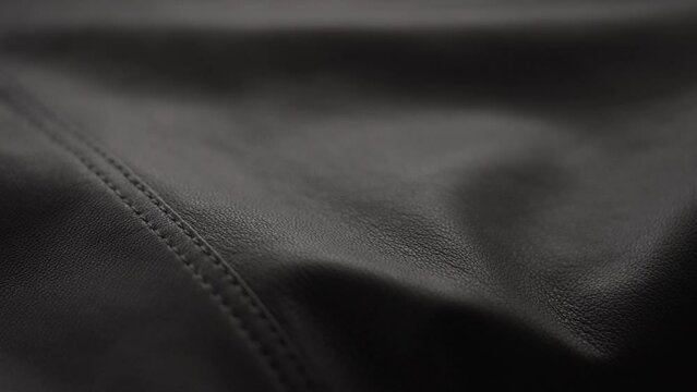 Slow motion handheld shot of soft gray brown leather closeup