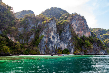 Fototapeta na wymiar A picturesque beautiful place on the island of Phi Phi Leh - Pi Leh Lagoon is popular for excursions with tourists on traditional Thai fishing boats. Island travel in Thailand.