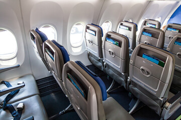 Economy class seats in the aircraft cabin with a small distance between the seats.