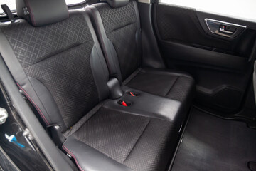 Close-up on rear seats with velours fabric upholstery in the interior of an modern japanese car in gray after dry cleaning. Auto service industry.