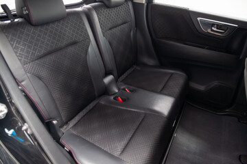 Close-up on rear seats with velours fabric upholstery in the interior of an modern japanese car in...