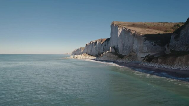 Aerial of impressive Normandy's white cliffs, round pebbles beaches and green pasture on the Alabaster Coast, France, 4K drone