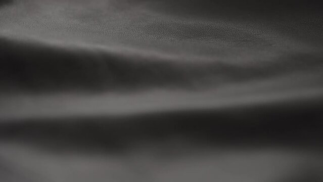 Slow motion handheld shot of soft gray brown leather closeup