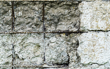 Damaged old concrete wall with exposed rebar