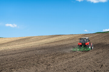 Obraz premium Tractor working in farm fields, rural landscape