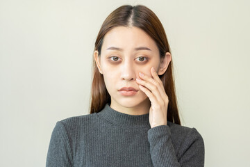 Bored, insomnia asian young woman, girl looking at camera, hand touching under eyes with problem of black circles or panda puffy, swollen and wrinkle on face. Sleepless, sleepy healthcare person.