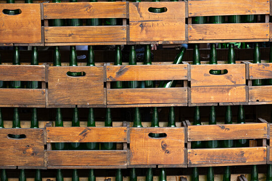 Cajas de madera con botellas de vidrio verde.