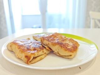 Delicious appetizing fried with crust stuffed pancakes on a plate