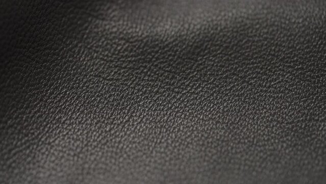 Slow motion handheld shot of soft gray brown leather closeup