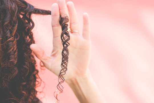 Close-Up of a woman's hand holding a ringlet of hair
