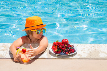 Child in swimming pool playing in summer water. Vacation and traveling with kids. Summer fruits for children. - Powered by Adobe