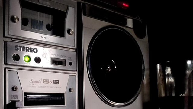 inserting cassette into a classic boombox old style listening music technology