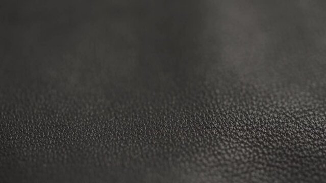 Slow motion closeup slide shot of soft gray brown leather