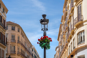 Lamppost with flowers at Calle Larios - famous pedestrian and shopping street - Malaga, Andalusia,...