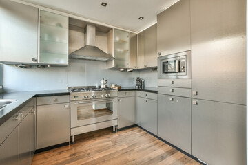 a modern kitchen with wood flooring and stainless steel appliances on the counters in this apartment's kitchen