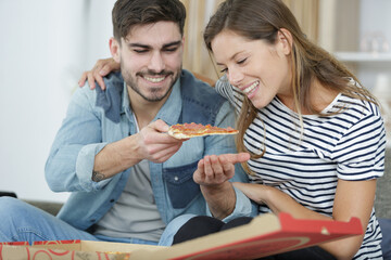 happy couple is eating pizza