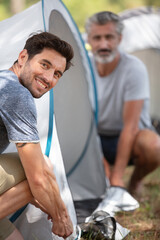 two men assembling a tent
