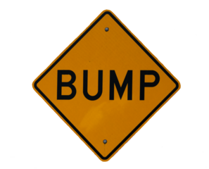 An isolated road sign with the text "Bump" against a blank background