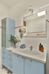 a modern bathroom with blue cabinets and white tiles on the walls, along with a large mirror over the sink