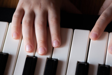 Children's hands learn to play the piano